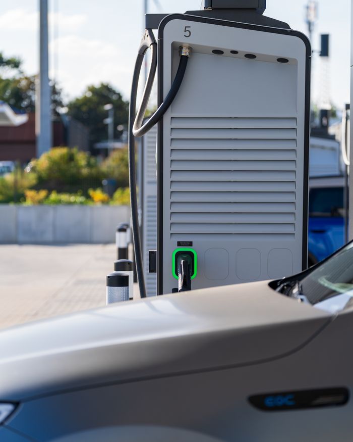 Electric car charging at a modern outdoor station, showcasing eco-friendly technology.